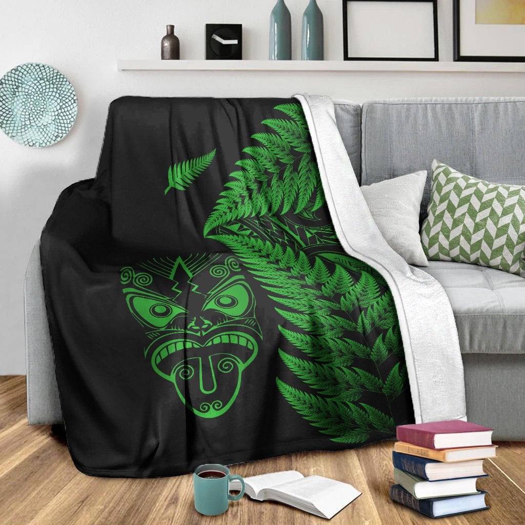Black blanket with green fern leaves and Maori face, with white backing/trim