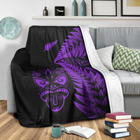 Black blanket with purple Maori face and fern pattern, white reverse lining on edge