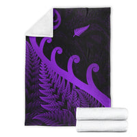 Folded purple and black blanket set with koru and fern motifs; white backing shown.