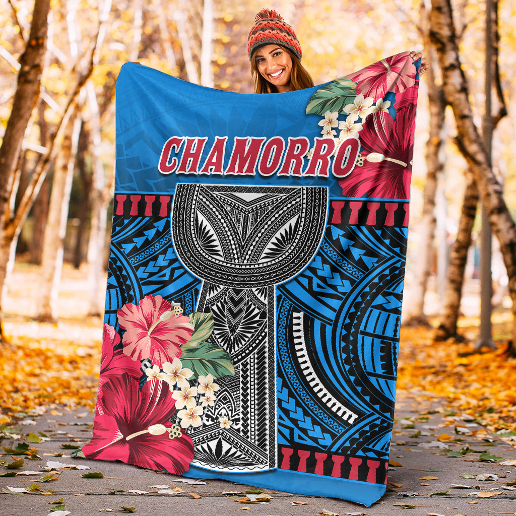 Blue blanket with CHAMORRO lettering, large red hibiscus flowers, and geometric tribal center
