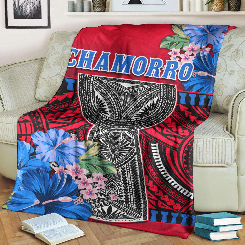 Red Polynesian blanket on sofa with Chamorro text and large blue flower graphics