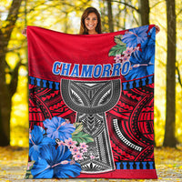 Red Polynesian blanket with Chamorro text, black-and-white mask, blue floral