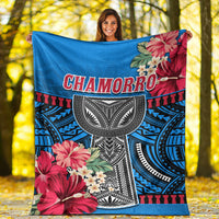 Blue polynesian blanket with CHAMORRO text, floral blooms, and black tribal pattern