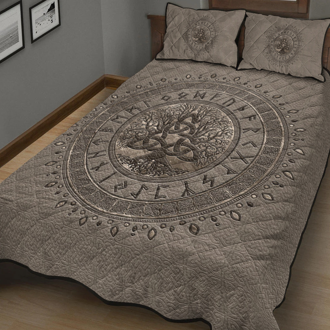 Light beige bed quilt featuring dark circular Tree of Life and runic border, with two pillows