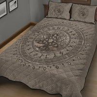 Light beige bed quilt featuring dark circular Tree of Life and runic border, with two pillows