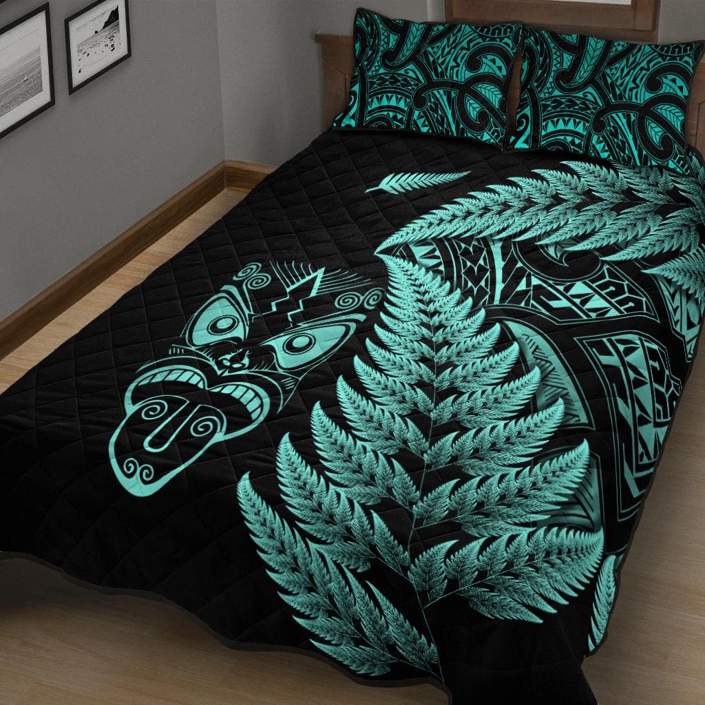 Black quilt with turquoise fern canopy, Maori mask art, and matching turquoise-pattern pillows
