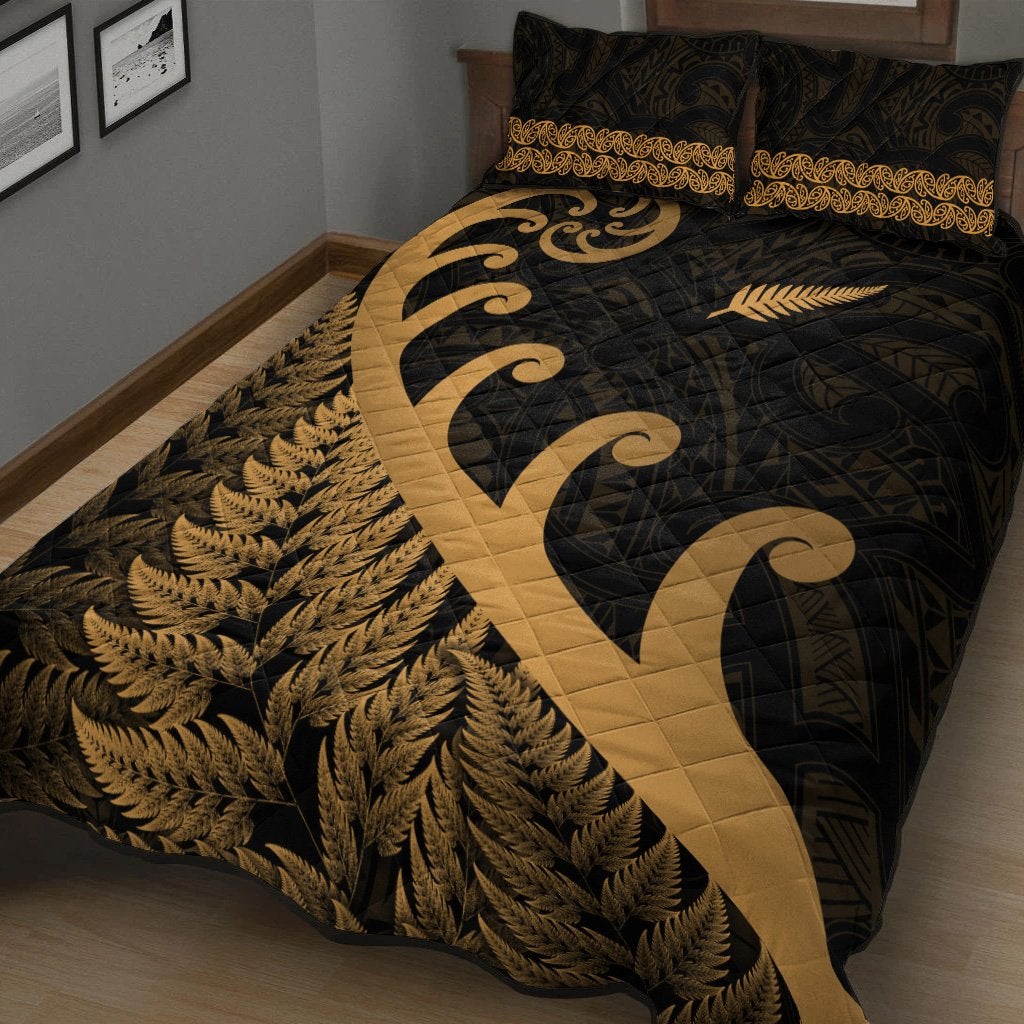 Black quilt with gold koru motif, fern leaf print, and gold decorative band