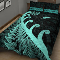 Turquoise fern quilt with black geometric background and koru curve quilted stitch