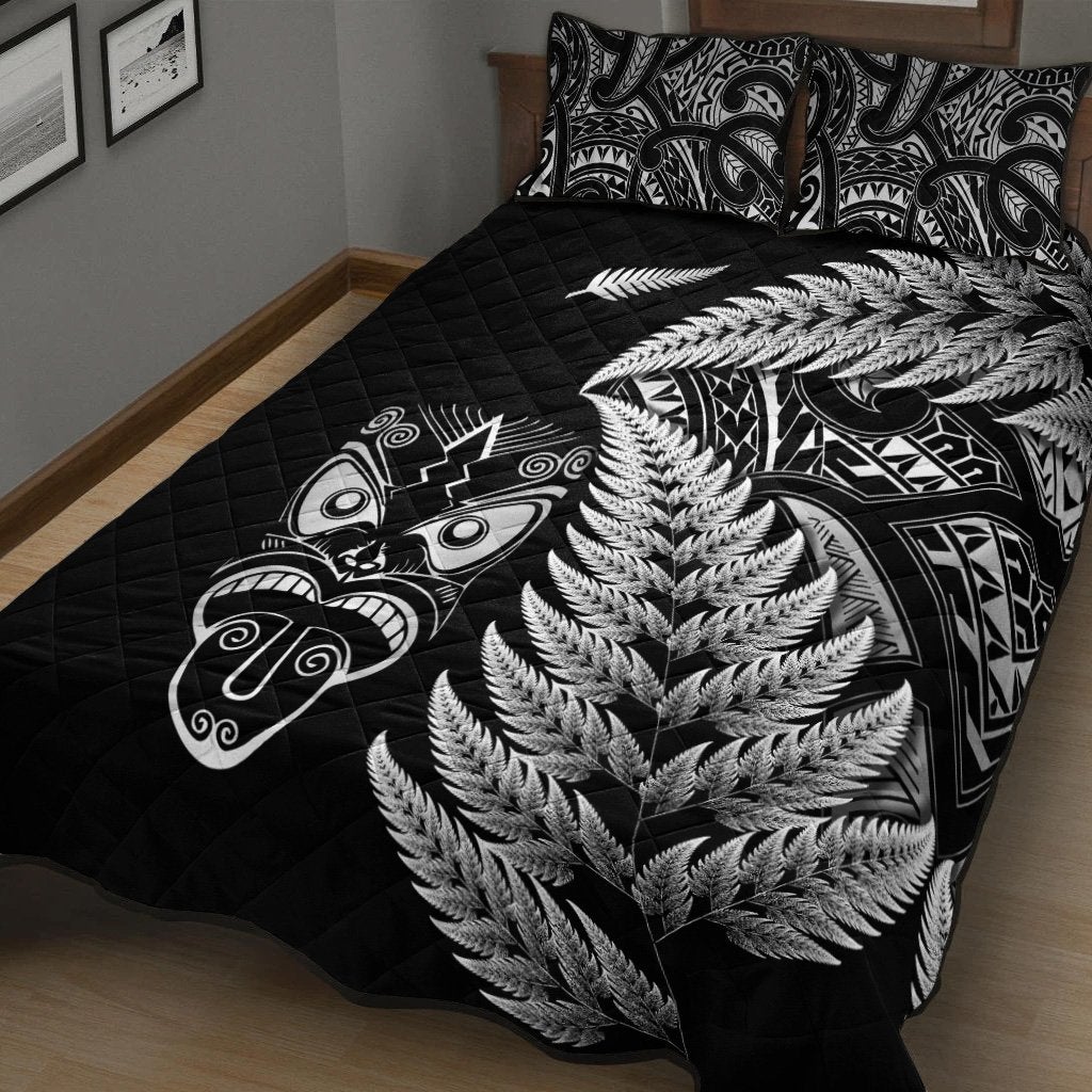 Black quilt bed set showing large silver fern pattern over quilt stitching