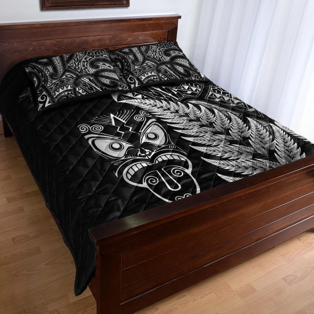 Black quilt bed set with silver fern and Maori mask motifs on quilted comforter