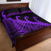 Purple and black quilt bed set draped on bed, fern border and koru motifs