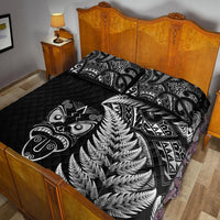 Black quilt bed set with silver fern design and Maori tribal patterns, with two pillows