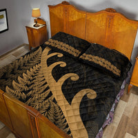 Black quilt with gold koru scroll, fern leaf border, and gold-trimmed pillow tops