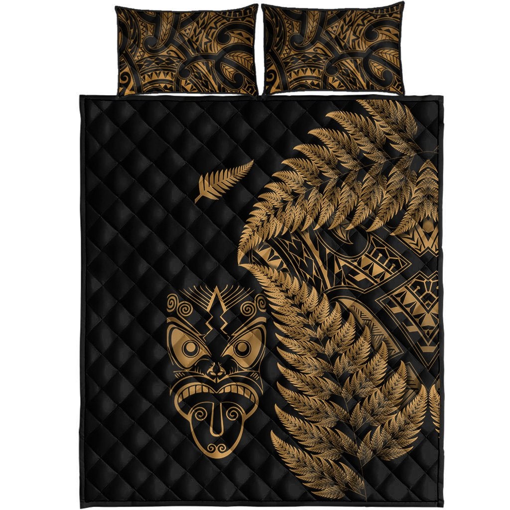 Set view: black quilt and 2 pillows with gold fern, tribal mask, and patterned motifs