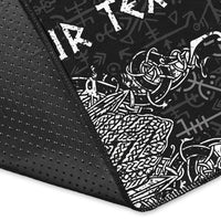 Close-up of black rug edge with dotted texture and white rune print