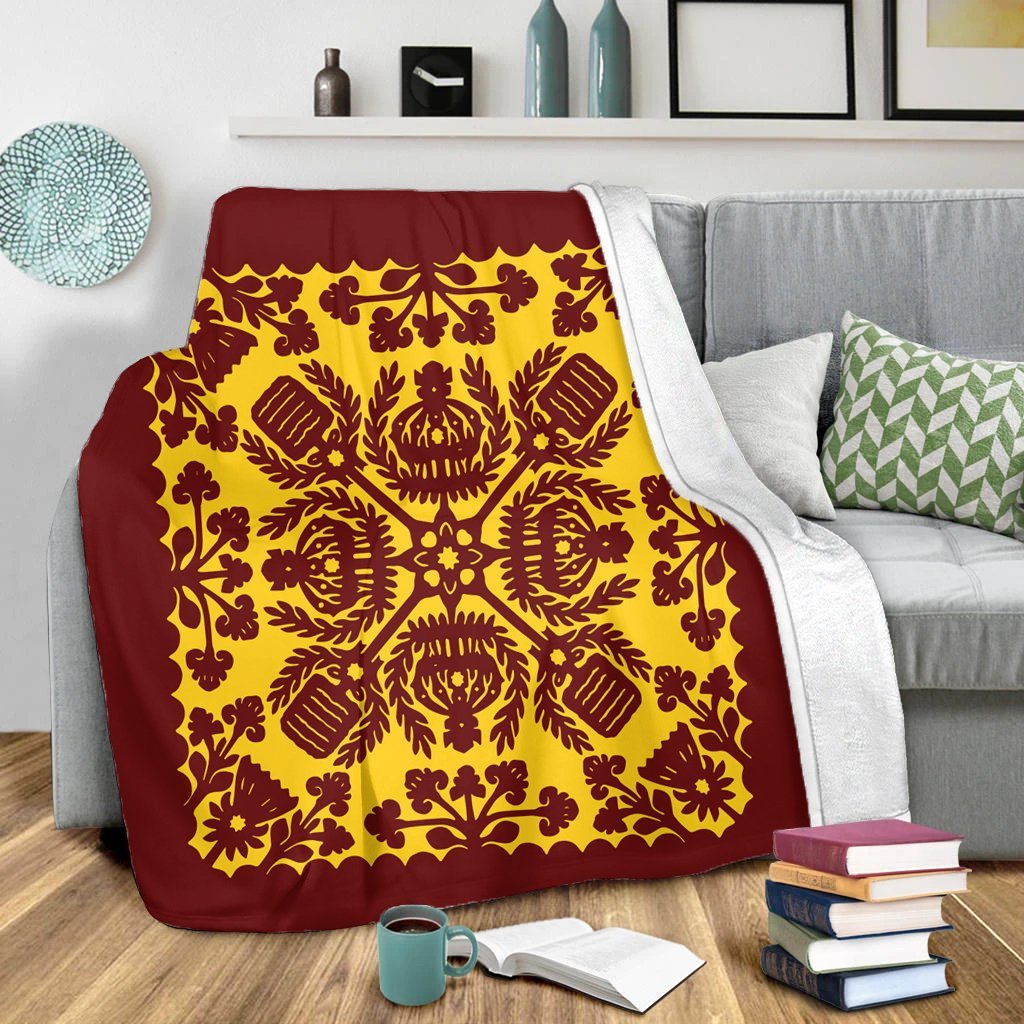 Red and yellow quilt-style blanket draped over couch with scalloped border and floral print