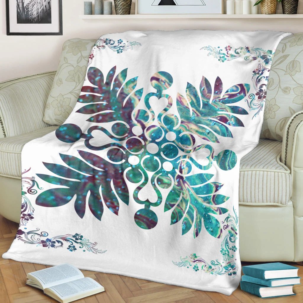 White blanket draped on sofa, showing teal hibiscus and tropical plant design