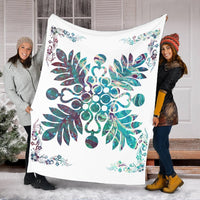 Shell white blanket held up, featuring teal hibiscus flower and vine detailing