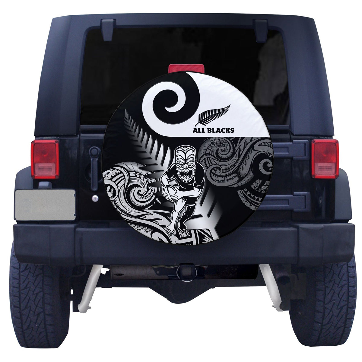Circular black spare tire cover with white All Blacks logo and ornate tribal design