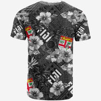 Black crewneck graphic T-shirt with hibiscus flowers, palms, and flag emblems
