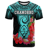 Turquoise and black T-shirt with CHAMORRO and large guam figure amid flowers.