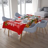 Red Christmas tablecloth with Santa in green hat, tropical motifs, on dining table