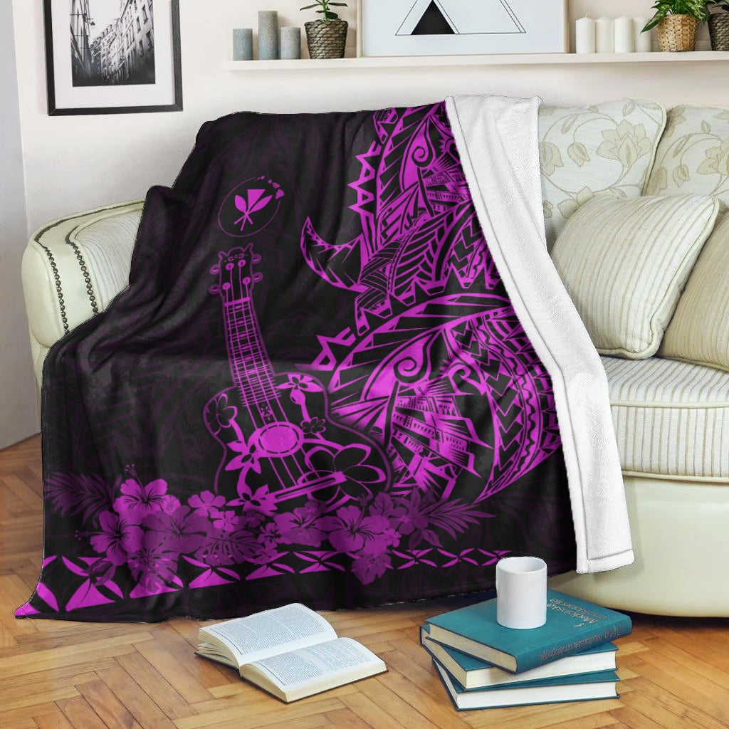 Black and purple Hawaiian blanket draped on couch, ukulele and floral geometric print
