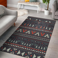 Dark charcoal area rug with tribal elephant motif and red, teal, cream geometric stripes