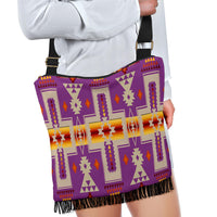 Crossbody bag held by model, purple tribal print, black fringe, adjustable strap
