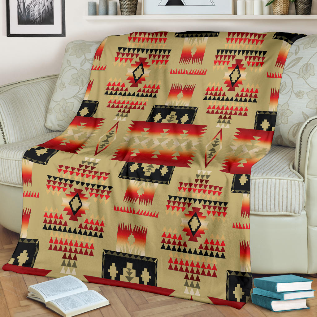 Light brown Native-style blanket draped on couch, repeating red and black motifs