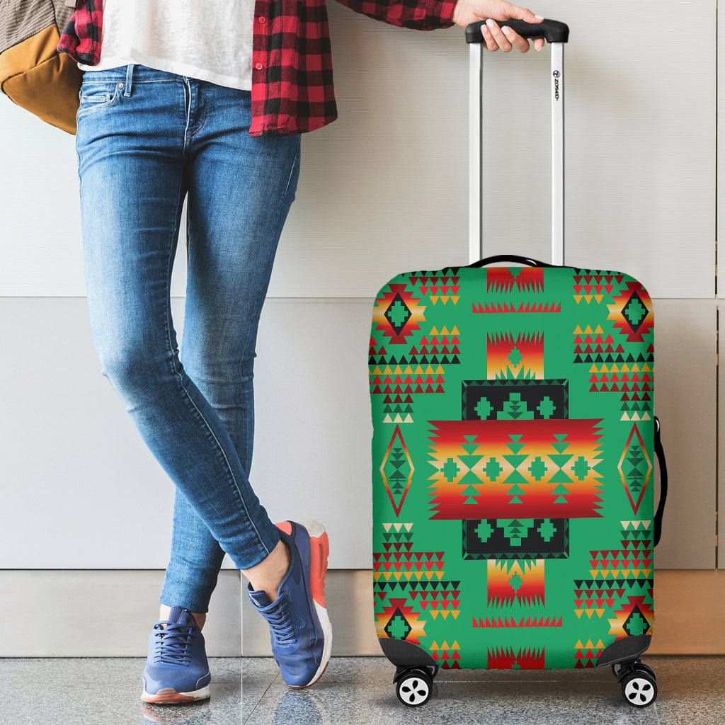 Green multicolor Native-style luggage cover on rolling suitcase beside standing person