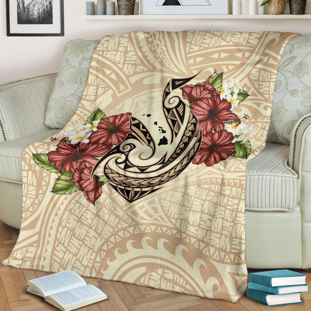 Beige Polynesian blanket featuring fish hook design with red hibiscus and plumeria flowers