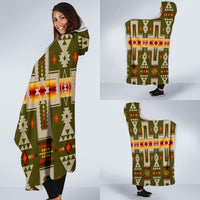 Hooded blanket with multicolor geometric design, olive base; draped on model