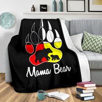 Black blanket spread on bed with bear paw emblem and 'Mama Bear' printed text
