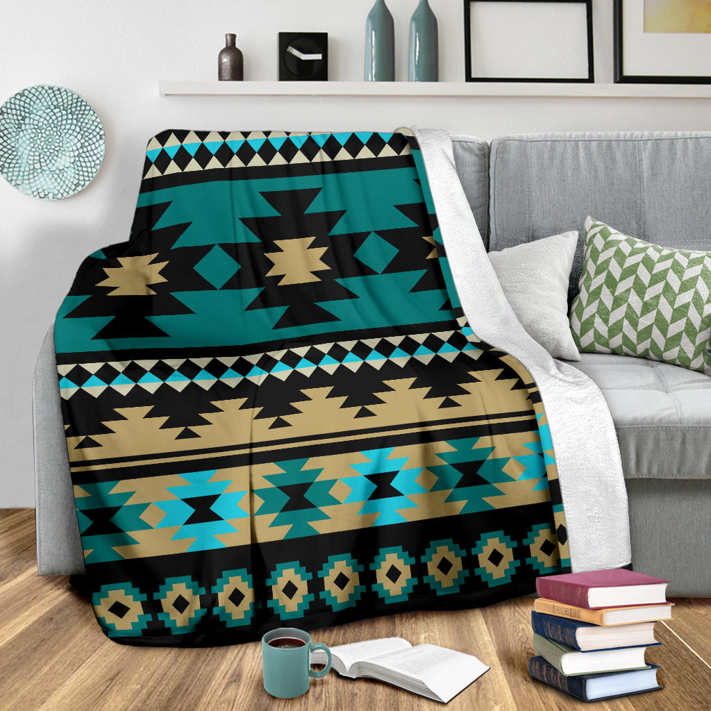 Folded teal Aztec blanket with black and tan starburst motifs