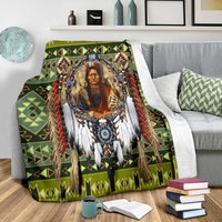 Green multicolor chief blanket with geometric border and fringe accents on couch