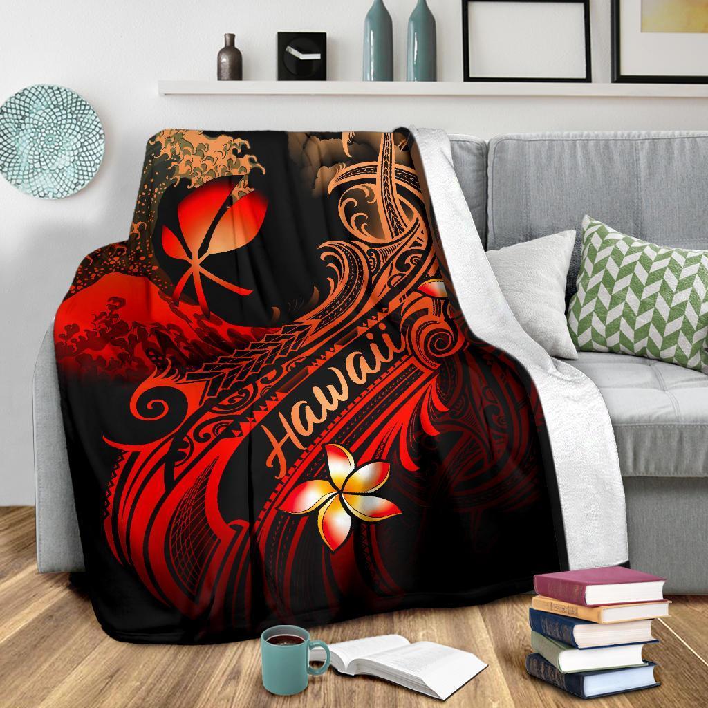 Black throw blanket draped on a sofa; red plumeria, “Hawaii” text, and tribal wave pattern