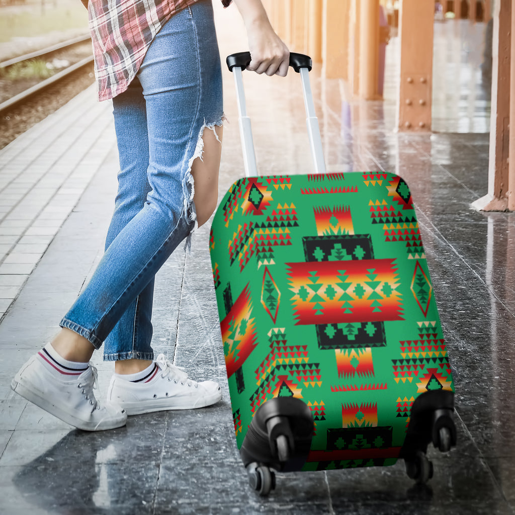 Green multicolor Native-style luggage cover on rolling suitcase, front near pavement