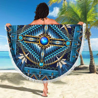 Blue mandala beach blanket held up, showing central round emblem and white fringe border