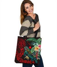 Large black shopper tote with teal turtle, red patterns, hibiscus and greenery graphic.
