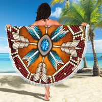 Round native-inspired mandala beach blanket, blue turquoise rays, red and white beaded shapes, fringe