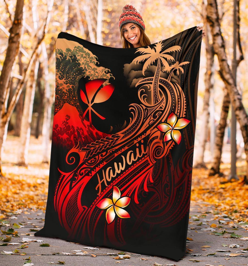 Black outdoor blanket showing red plumeria flowers, palm trees, and “Hawaii” stripe design