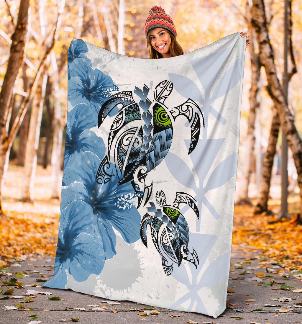 Blue Polynesian turtle and hibiscus blanket held outdoors, large design in view