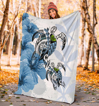 Blue Polynesian turtle and hibiscus blanket held outdoors, large design in view