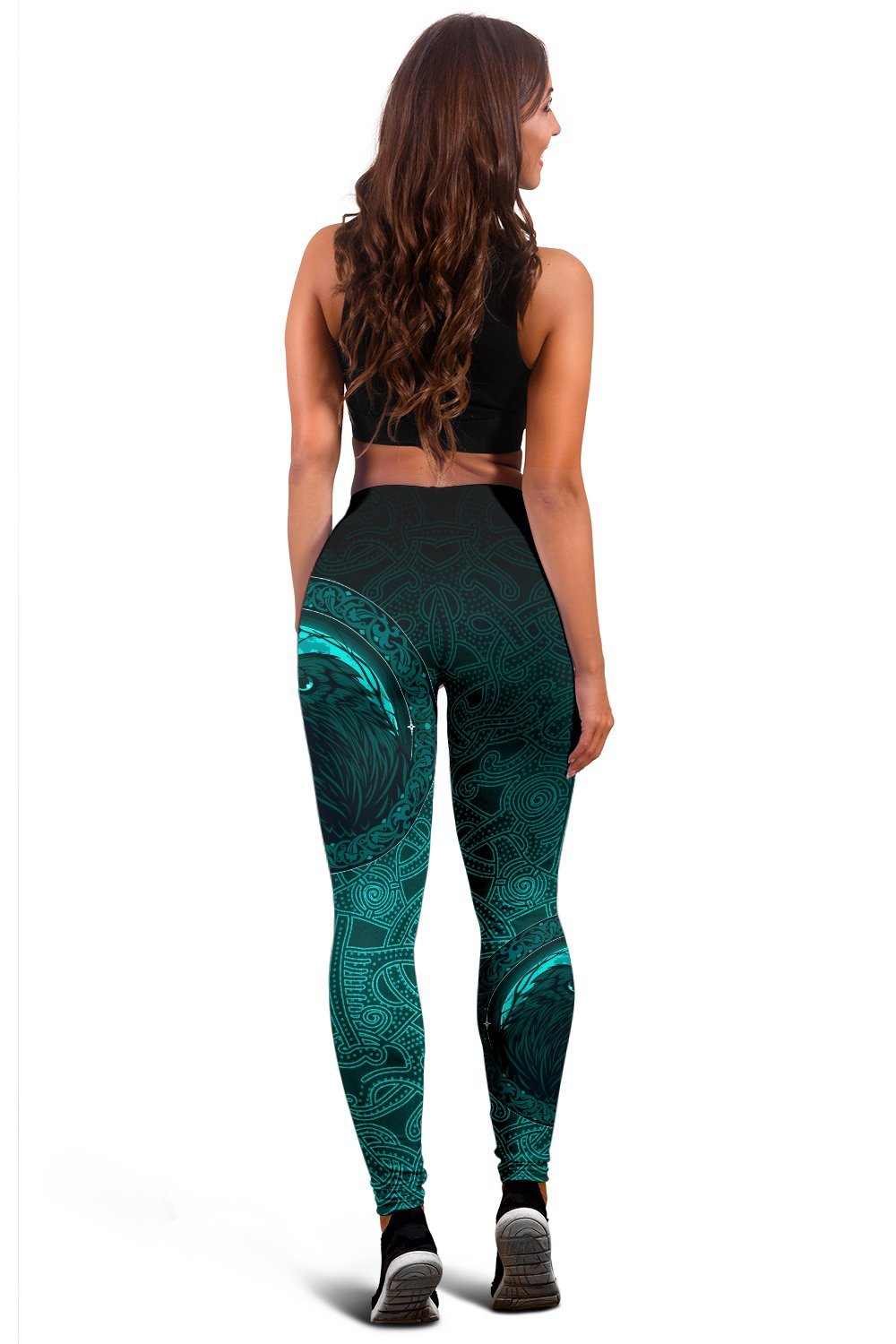 Back view black and teal leggings with raven face motif centered on thigh