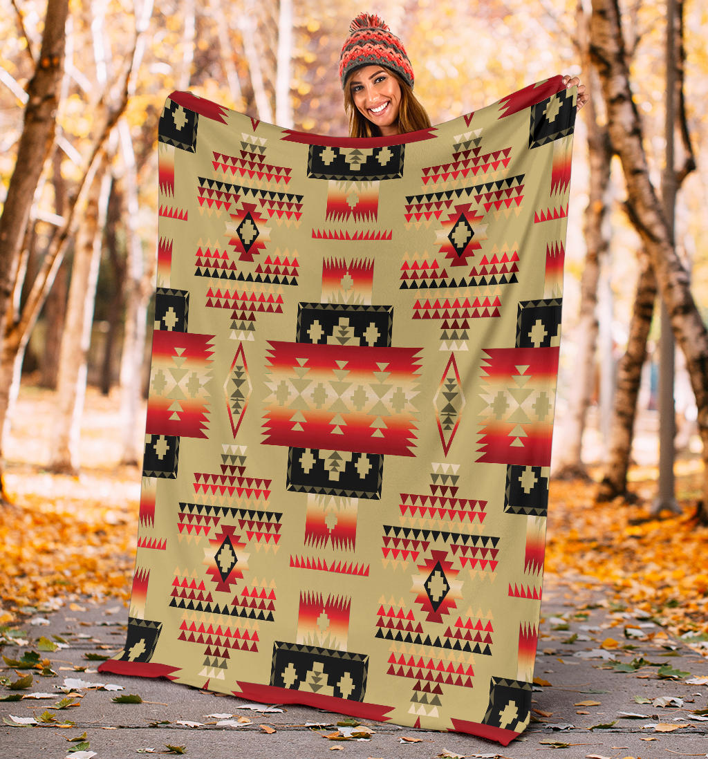 Light brown Native-style blanket with red, black, and tan triangles and block designs