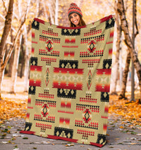 Light brown Native-style blanket with red, black, and tan triangles and block designs