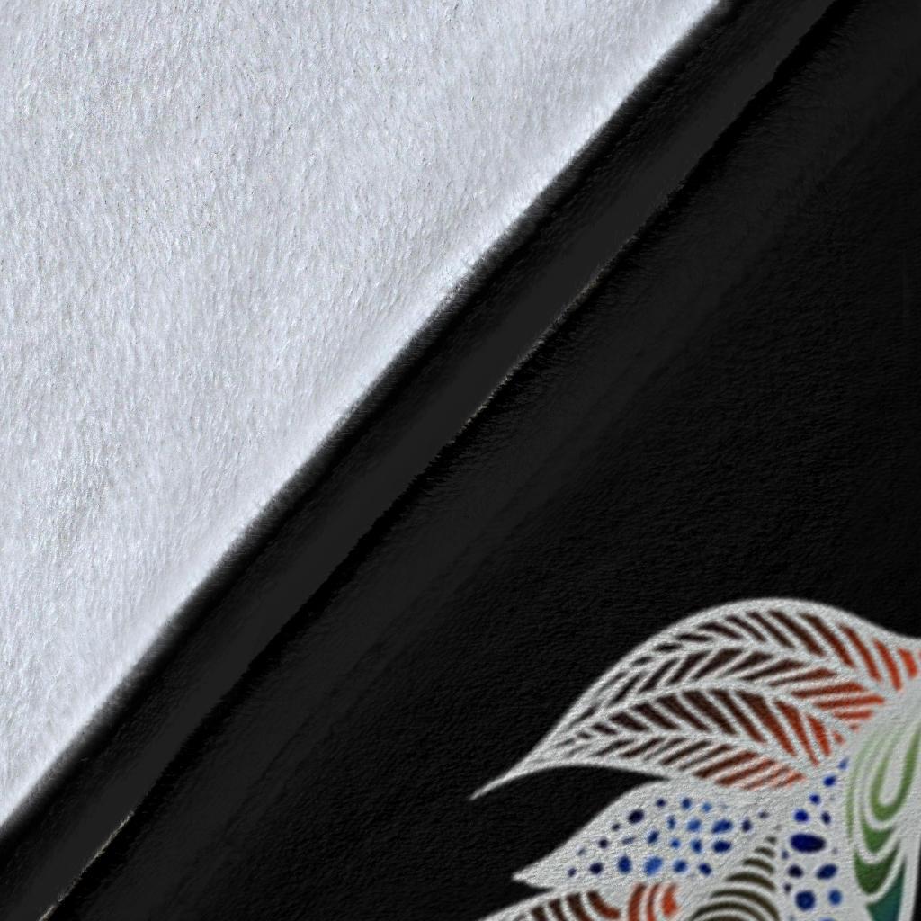 Close-up of black blanket fabric with colorful feather print and partial mandala detail