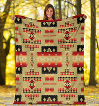 Light brown Native-style blanket with red sunburst band and repeating triangle patterns