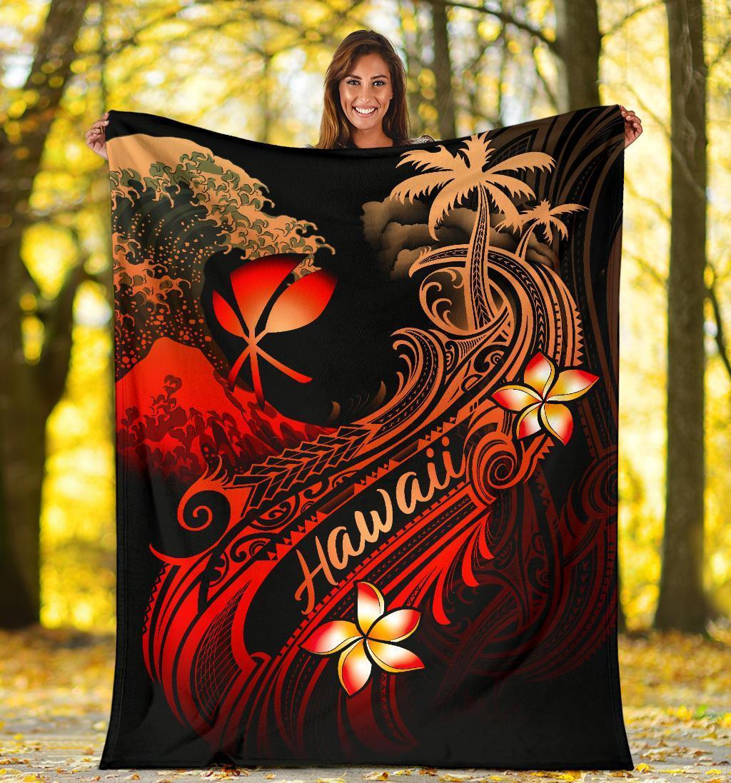 Black blanket held up outdoors with red “Hawaii” lettering, plumeria blooms, and waves